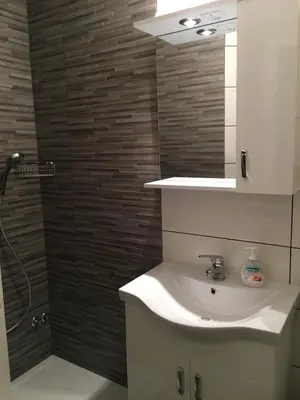a bathroom with a sink and a shower with a mirror at Guest House Golja in Bled