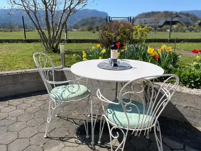 a white table with two chairs and a vase on it at Guest House Golja in Bled