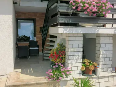 a patio with flowers in pots on a building at Guest House Golja in Bled