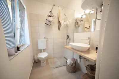 a white bathroom with a sink and a toilet at Casa No. 51 in Kog