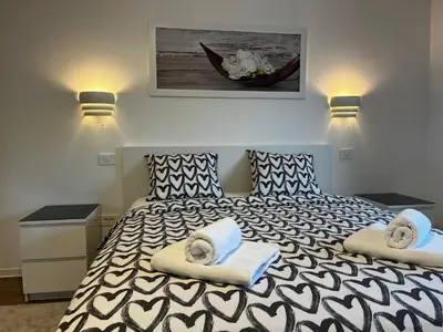 a bedroom with a black and white bed with towels on it at Villa Kovačeva apartments, Marice Kovačeve 15, app 1, free parking in Ljubljana