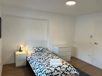 a bedroom with a bed with a blue and white blanket at Villa Kovačeva apartments, Marice Kovačeve 15, app 1, free parking in Ljubljana