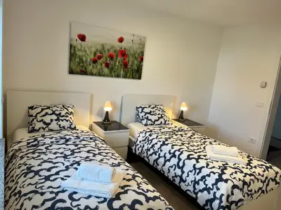 a bedroom with two beds and a painting on the wall at Villa Kovačeva apartments, Marice Kovačeve 15, app 1, free parking in Ljubljana