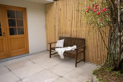 a bench with a blanket on it next to a door at Olga & Ludvik country apartment in Podbrdo