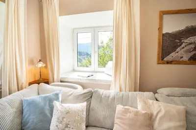 a living room with a couch and a window at Olga & Ludvik country apartment in Podbrdo