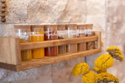 a wooden shelf with bottles of oils on a wall at Olga & Ludvik country apartment in Podbrdo