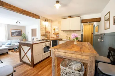 a kitchen and living room with a wooden table at Olga & Ludvik country apartment in Podbrdo