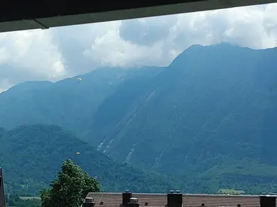 a view of a mountain range with kites in the sky at Apartma Eda, Bovec in Bovec