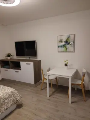 a living room with a white table and a tv at Apartma Eda, Bovec in Bovec
