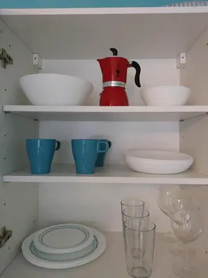 a shelf with dishes and a tea pot and glasses at Apartma Eda, Bovec in Bovec