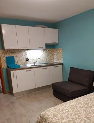 a kitchen with a sink and a couch in a room at Apartma Eda, Bovec in Bovec