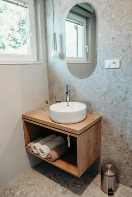 a bathroom with a sink and a mirror at Apartments Triglav in Mojstrana