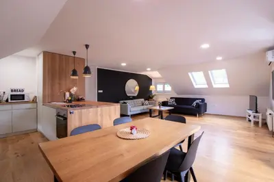 a kitchen and living room with a wooden table and a dining room at River Valley Vista Apartment in Bohinjska Bela