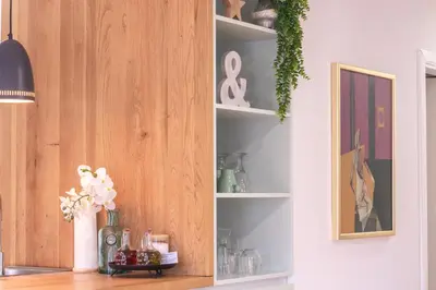 a kitchen cabinet with a vase of flowers on a table at River Valley Vista Apartment in Bohinjska Bela
