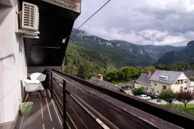 a balcony with a chair and a view of mountains at River Valley Vista Apartment in Bohinjska Bela