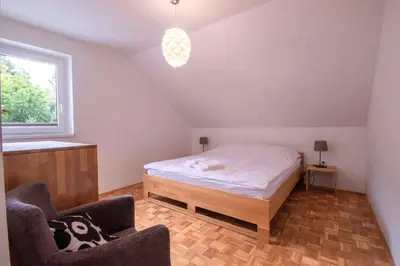 a bedroom with a bed and two chairs in it at River Valley Vista Apartment in Bohinjska Bela