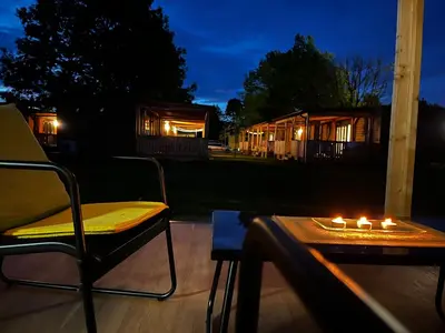 a couple of chairs and a table with candles on a patio at Premium mobile home Eden in Velenje