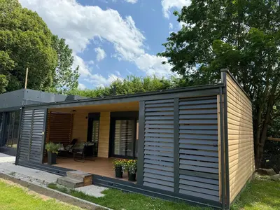 a modular house with a deck in a yard at Premium mobile home Eden in Velenje
