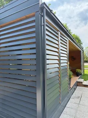 a building with a metal shutter on the side of it at Premium mobile home Eden in Velenje
