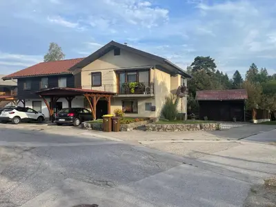 a house with cars parked in front of it at Apartma Šohen in Kočevje