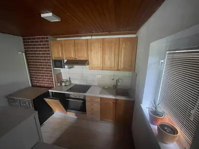 an overhead view of a small kitchen with wooden cabinets at Apartma Šohen in Kočevje