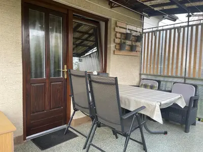 a table and chairs sitting next to a door at Apartma Šohen in Kočevje