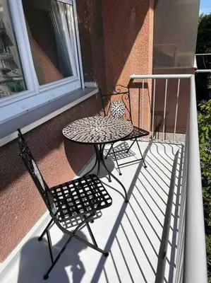 two chairs and a table on a balcony at Spacious Apartment - green & peaceful in Ljubljana
