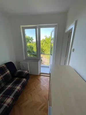 a living room with a couch and a window at Spacious Apartment - green & peaceful in Ljubljana