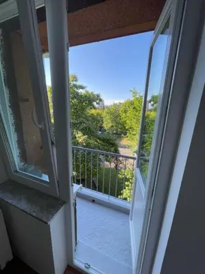 an open door with a view of a balcony at Spacious Apartment - green & peaceful in Ljubljana