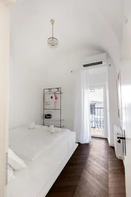 a white bedroom with a large bed and a window at Swanky Residence, 4 stars, city centre in Ljubljana