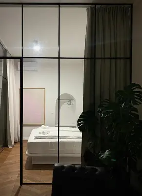 a bedroom with a bed and a glass wall at Swanky Residence, 4 stars, city centre in Ljubljana