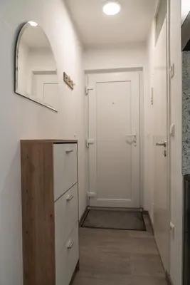 a hallway with a white door and a mirror at Apartma Nadja in Maribor