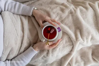a woman holding a cup of coffee on a bed at Apartment Rosemary in Topolšica
