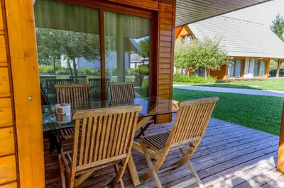 a glass table and chairs on a wooden deck at Apartment Rosemary in Topolšica