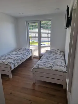 two beds in a room with a window at Cona rooms in Cerkvenjak
