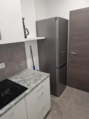 a kitchen with a stainless steel refrigerator and white cabinets at Cona rooms in Cerkvenjak