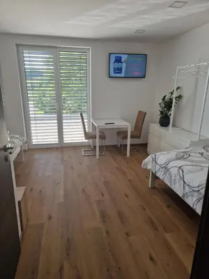 a bedroom with a bed and a desk and a table at Cona rooms in Cerkvenjak