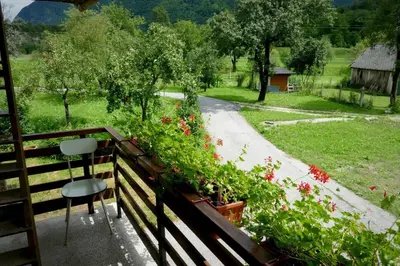 a balcony with a table and a chair and flowers at Holiday Home Over The River in Bovec