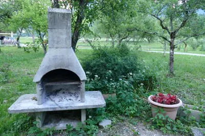 a stone oven with a flower pot in a field at Holiday Home Over The River in Bovec