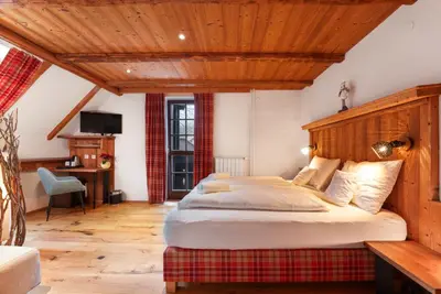 a bedroom with a large bed and a wooden ceiling at Gostilna Pri Martinu in Kranjska Gora