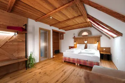 a bedroom with a large bed and wooden ceilings at Gostilna Pri Martinu in Kranjska Gora