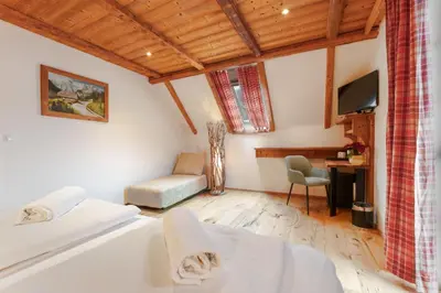 a bedroom with a bed and a desk and a tv at Gostilna Pri Martinu in Kranjska Gora