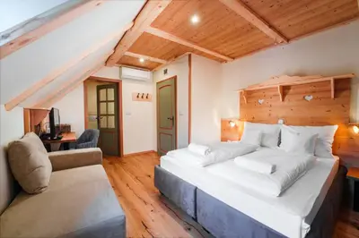 a bedroom with a large bed and a chair at Gostilna Pri Martinu in Kranjska Gora