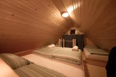 a room with two beds in a wooden room at Chalet Zlatica Velika Planina in Stahovica