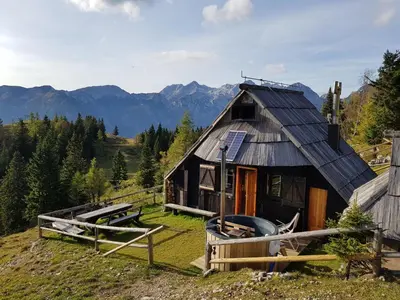 a cabin in the mountains with mountains in the background at Chalet Zlatica Velika Planina in Stahovica