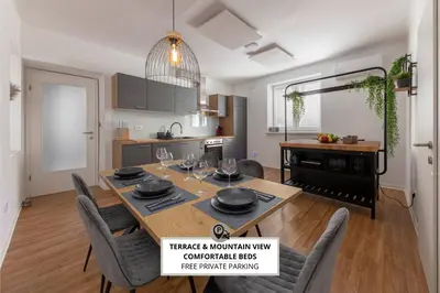 a kitchen and dining room with a table and chairs at Apartments Grahek in Ljubljana