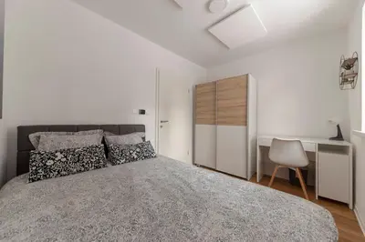 a bedroom with a large bed and a desk at Apartments Grahek in Ljubljana