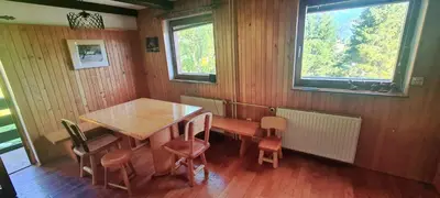 a dining room with a wooden table and chairs at Holiday House Jezerka in Bohinj