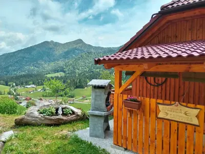 a wooden building with a bird feeder on the side of it at POČITNIŠKA HIŠKA LASTOVKA in Podvolovljek
