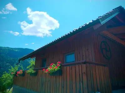 a building with flower boxes on the side of it at POČITNIŠKA HIŠKA LASTOVKA in Podvolovljek